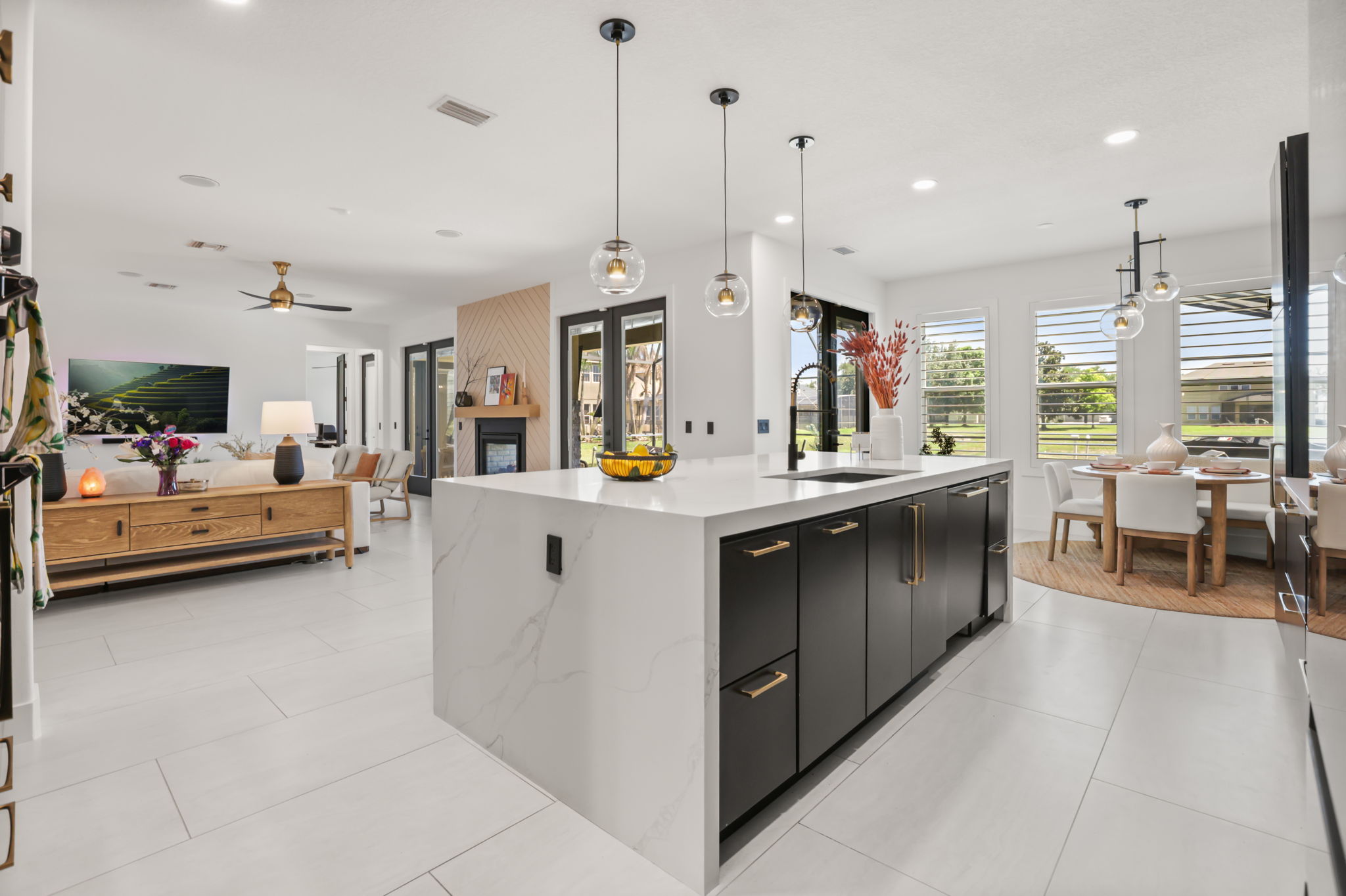 Kitchen with contrasting cabinetry, Calacatta Gold quartz waterfall island and pendant lighting